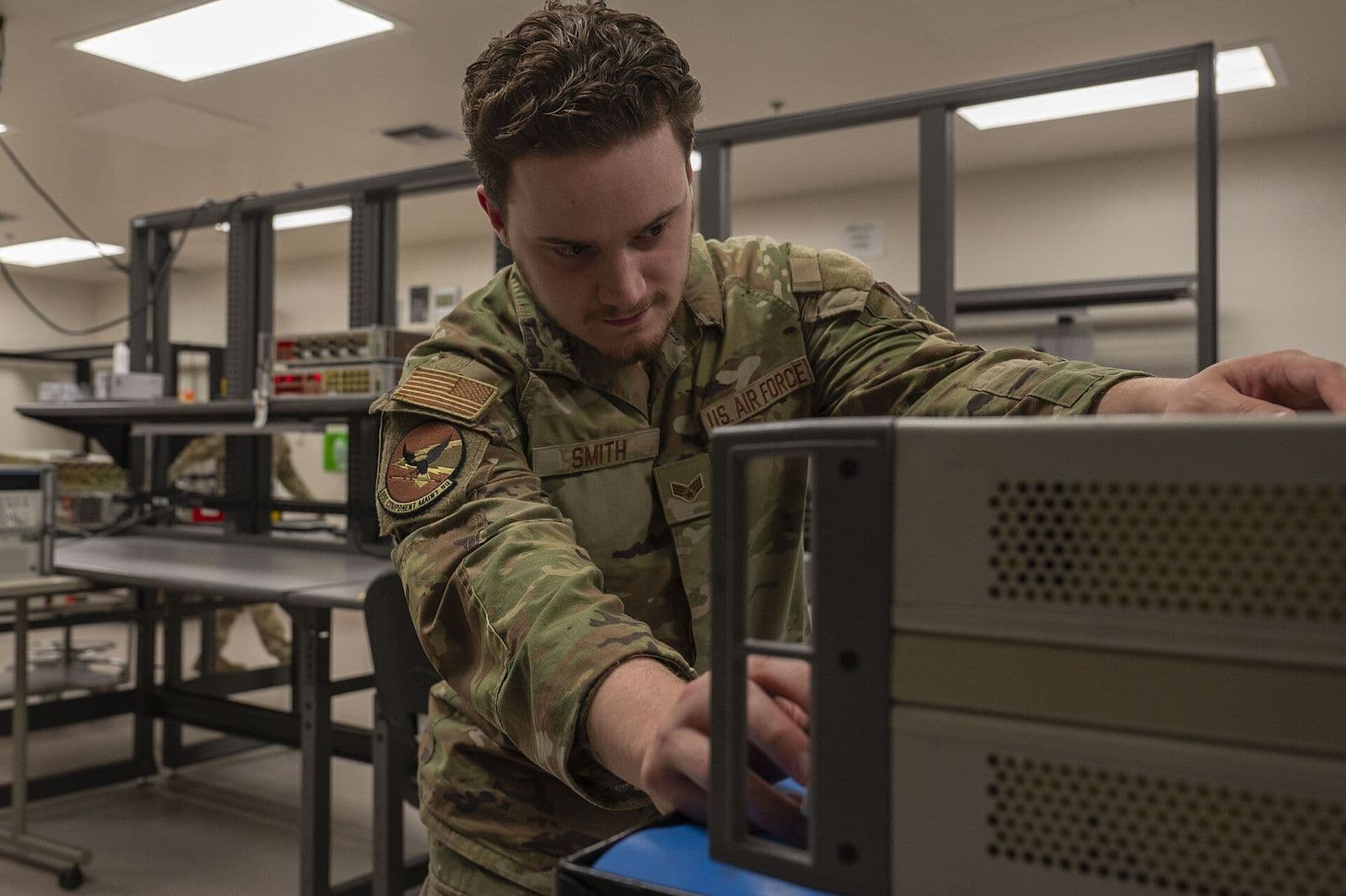 A metrology technician checks a voltage standard against a bench multimeter in a precision measurement laboratory